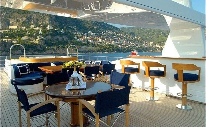 a table and chairs on a deck aboard OXYGEN Yacht for Sale