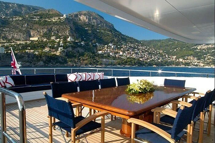 a table on a deck overlooking a body of water aboard OXYGEN Yacht for Sale