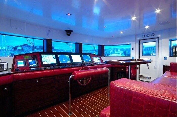 a room with red seats and tables aboard OXYGEN Yacht for Sale
