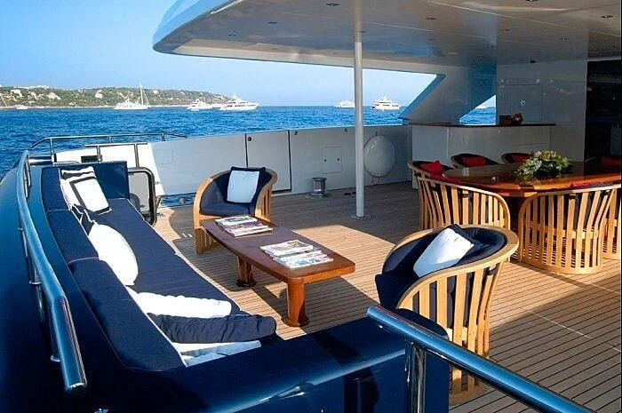 a deck with chairs and tables on it aboard OXYGEN Yacht for Sale