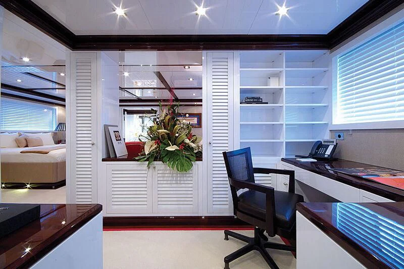 a room with a desk and a chair and a plant in the corner aboard OXYGEN Yacht for Sale