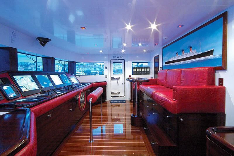 a room with a wood floor and red couches aboard OXYGEN Yacht for Sale