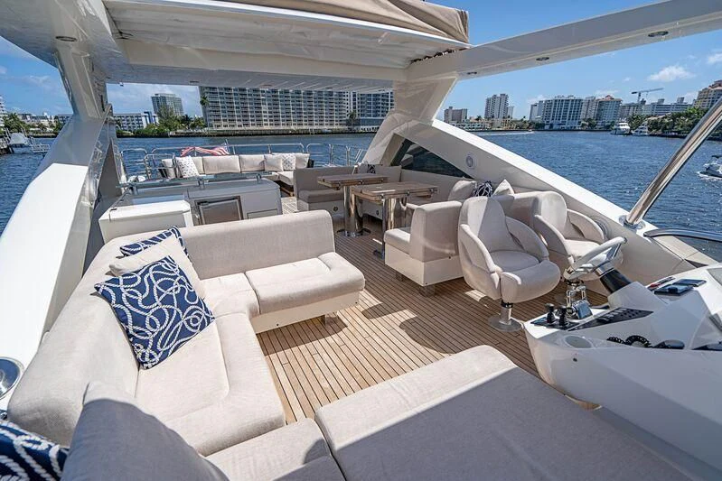 a large lounge area with a large body of water and a city in the background aboard FULL CIRCLE Yacht for Sale