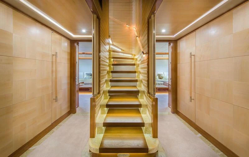 a long hallway with a set of stairs aboard OBSESSION Yacht for Sale