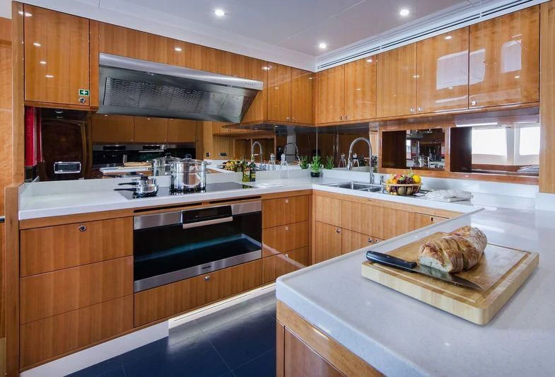 a kitchen with wooden cabinets aboard OBSESSION Yacht for Sale