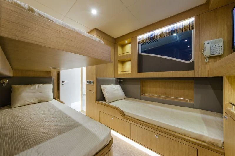 a room with a bed and a television aboard OBSESSION Yacht for Sale