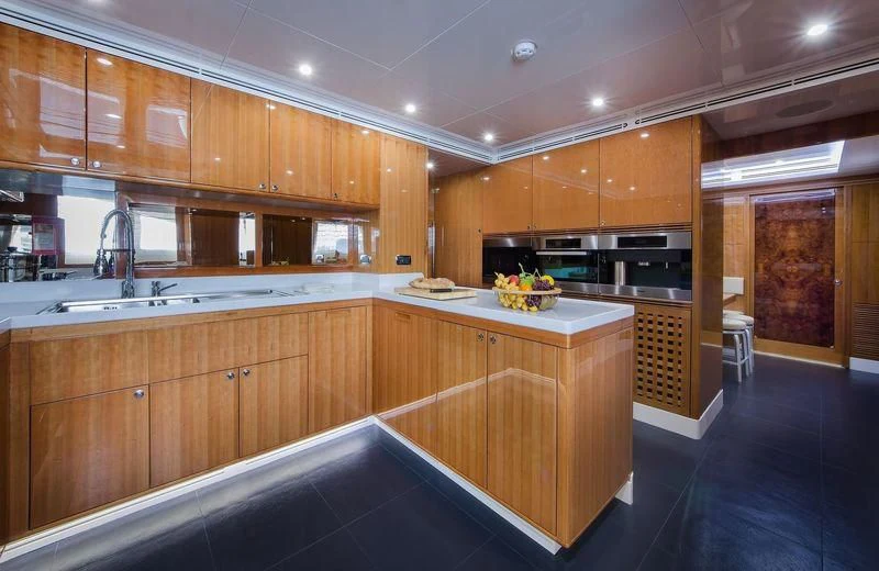 a kitchen with wooden cabinets aboard OBSESSION Yacht for Sale