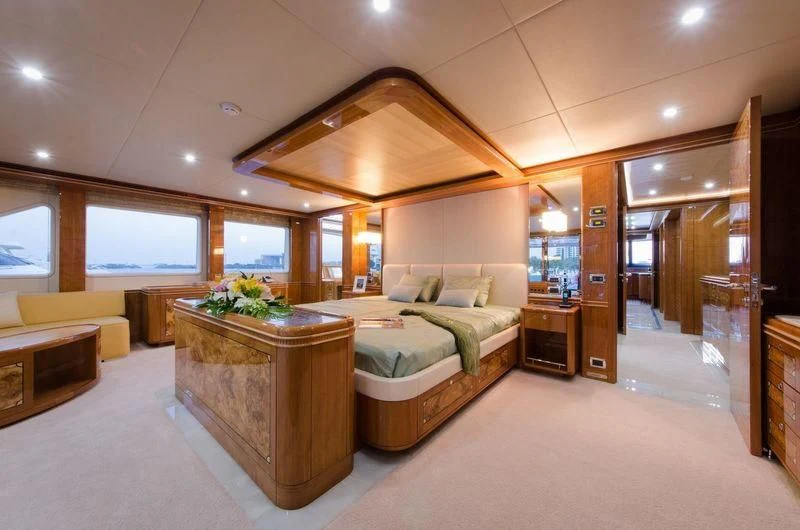 a room with a bed and a table aboard OBSESSION Yacht for Sale