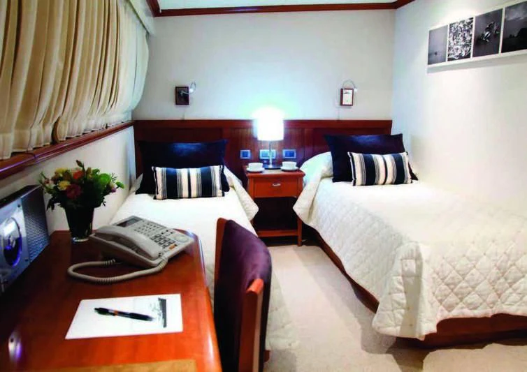 a hotel room with a bed and desk aboard ASTERIA Yacht for Charter