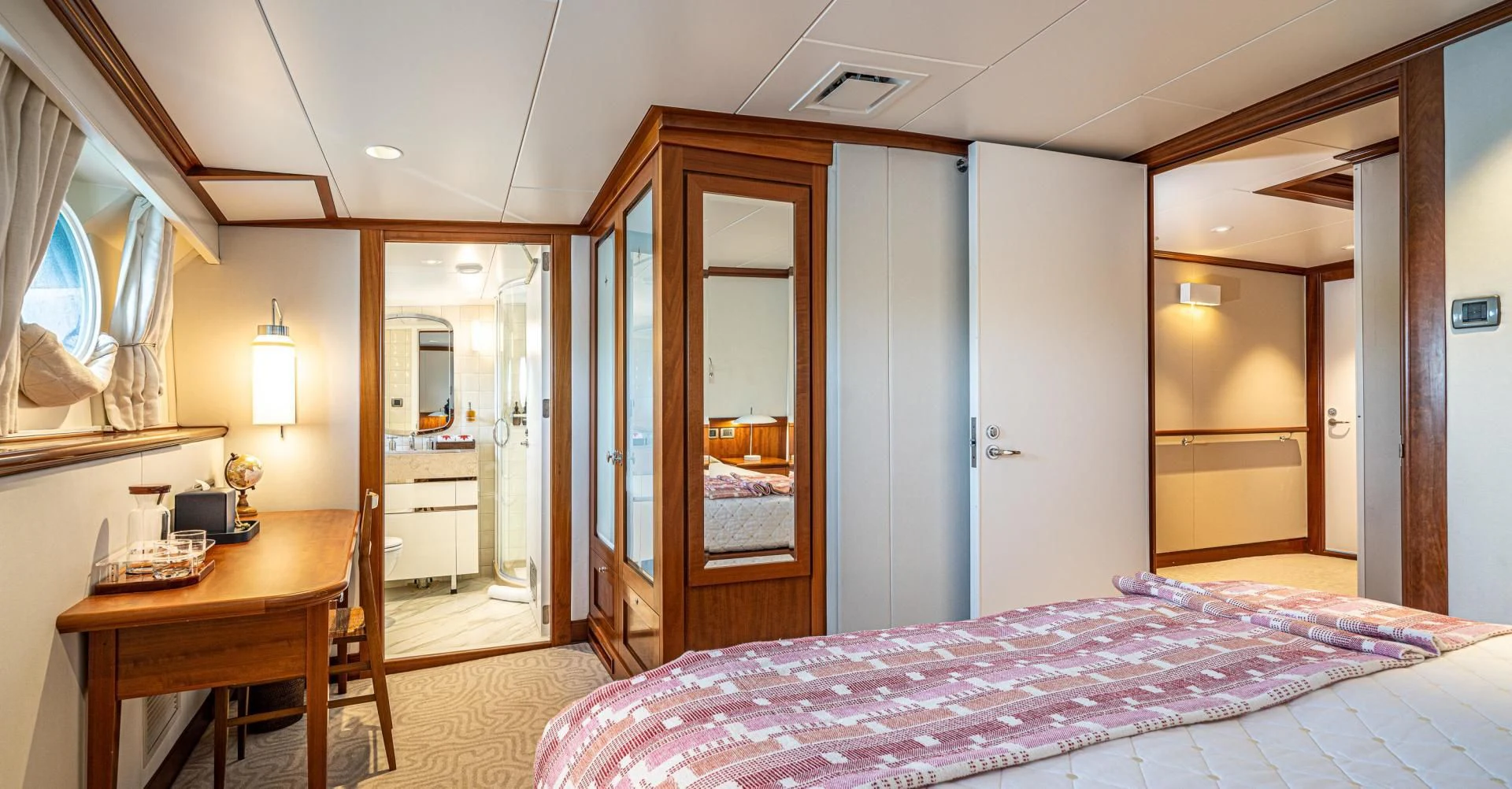 a bedroom with a bed and desk aboard ASTERIA Yacht for Charter