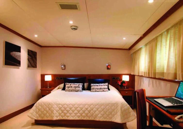 a bedroom with a bed and a laptop on the table aboard ASTERIA Yacht for Charter