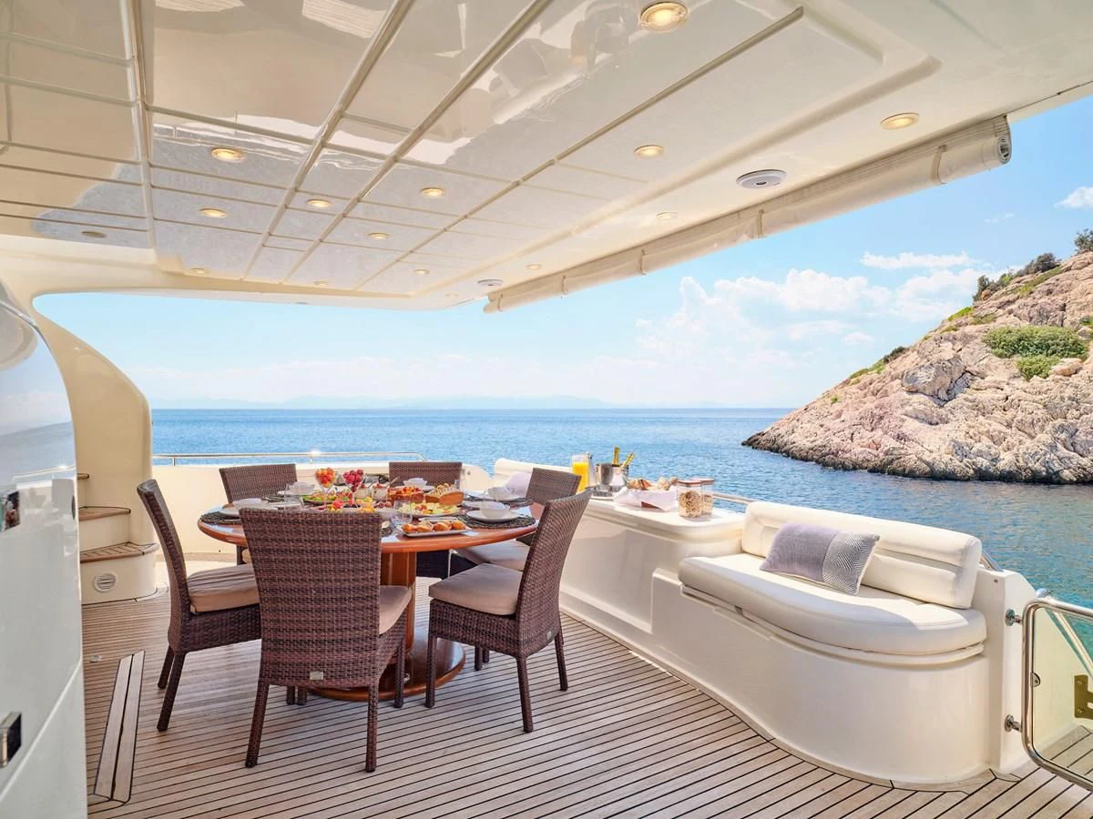 a table and chairs on a deck overlooking a large body of water aboard ESTIA YI Yacht for Sale