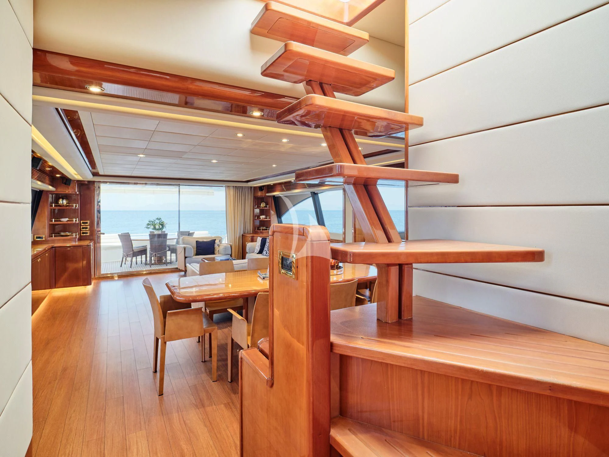 a room with a wood floor and a wood table with chairs and a large window aboard ESTIA YI Yacht for Sale