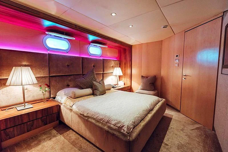a room with a bed and a lamp aboard TANGO Yacht for Sale