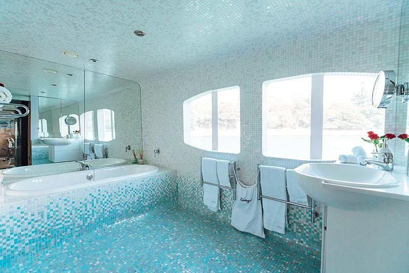 a bathroom with a tub sink and a mirror aboard TANGO Yacht for Sale