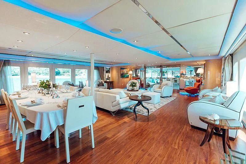 a large living room with a large table and chairs aboard TANGO Yacht for Sale