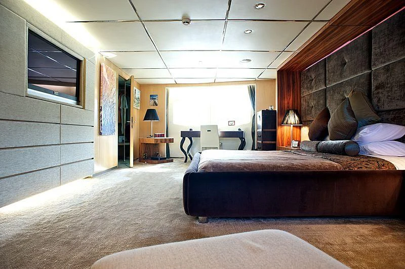 a bedroom with a bed and a desk aboard TANGO Yacht for Sale