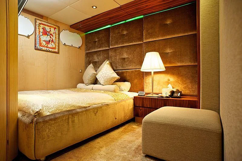 a bedroom with a bed and a lamp aboard TANGO Yacht for Sale