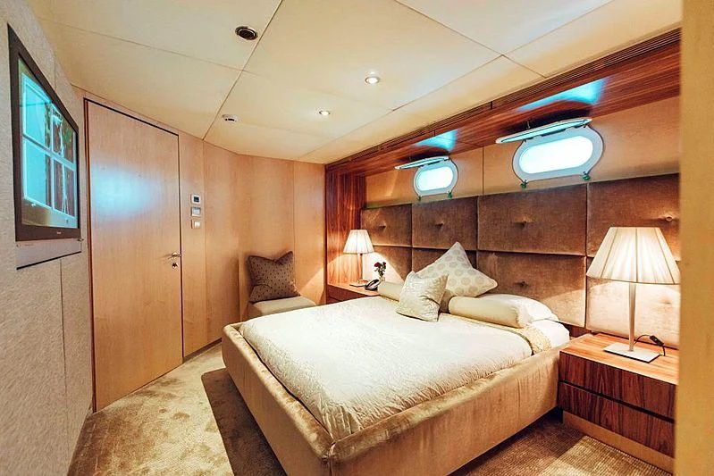 a bedroom with a bed and a desk aboard TANGO Yacht for Sale