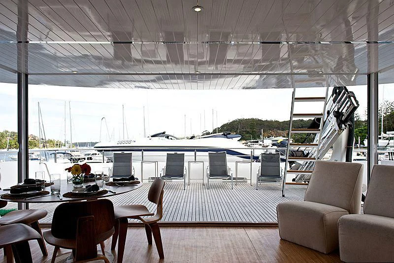 a room with a large window and a table with chairs and a view of the water aboard TANGO Yacht for Sale