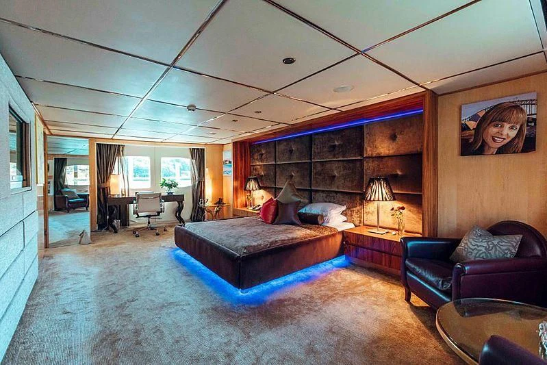 a large living room with a large blue couch and a large wood wall aboard TANGO Yacht for Sale