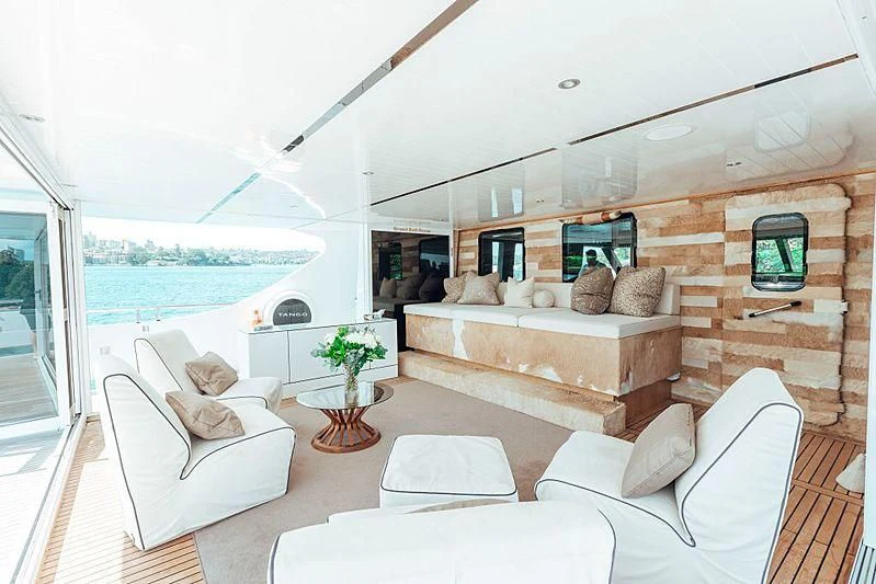 a living room with a large stone fireplace aboard TANGO Yacht for Sale