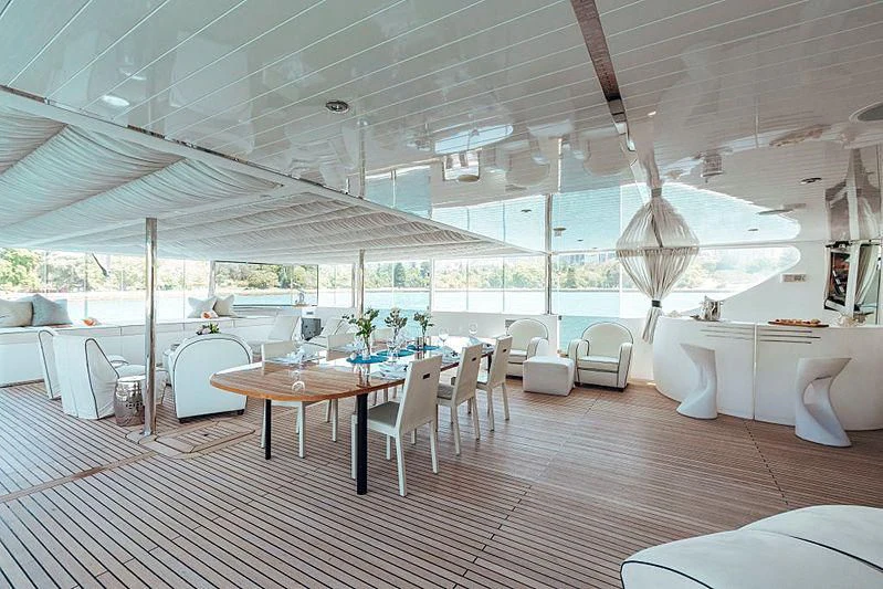 a room with tables and chairs aboard TANGO Yacht for Sale