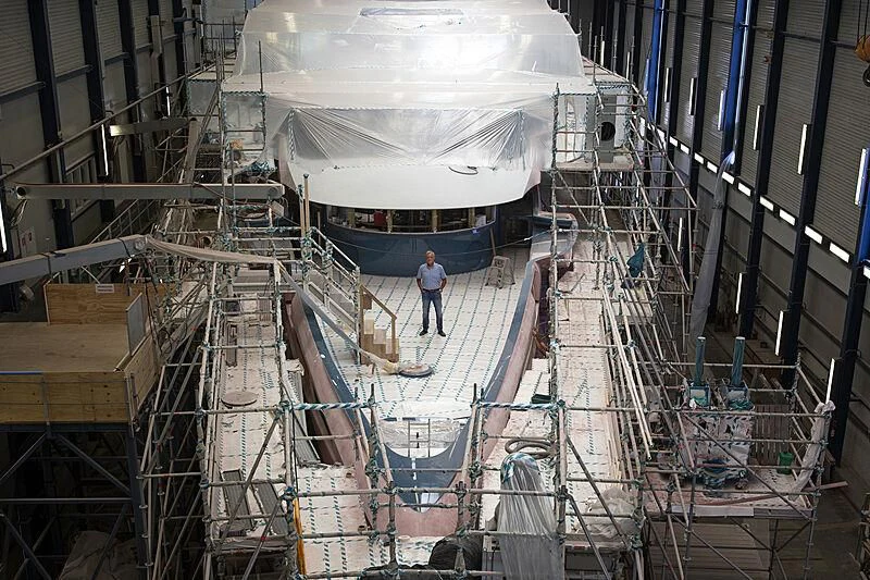a person standing in a large room with a large white object on the floor aboard PHI Yacht for Sale