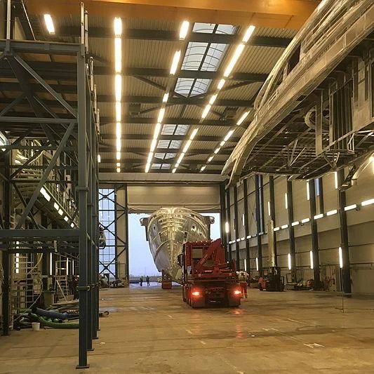 a large warehouse with a red car aboard PHI Yacht for Sale