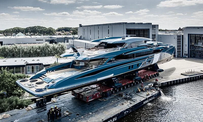a group of people standing next to a large boat aboard PHI Yacht for Sale