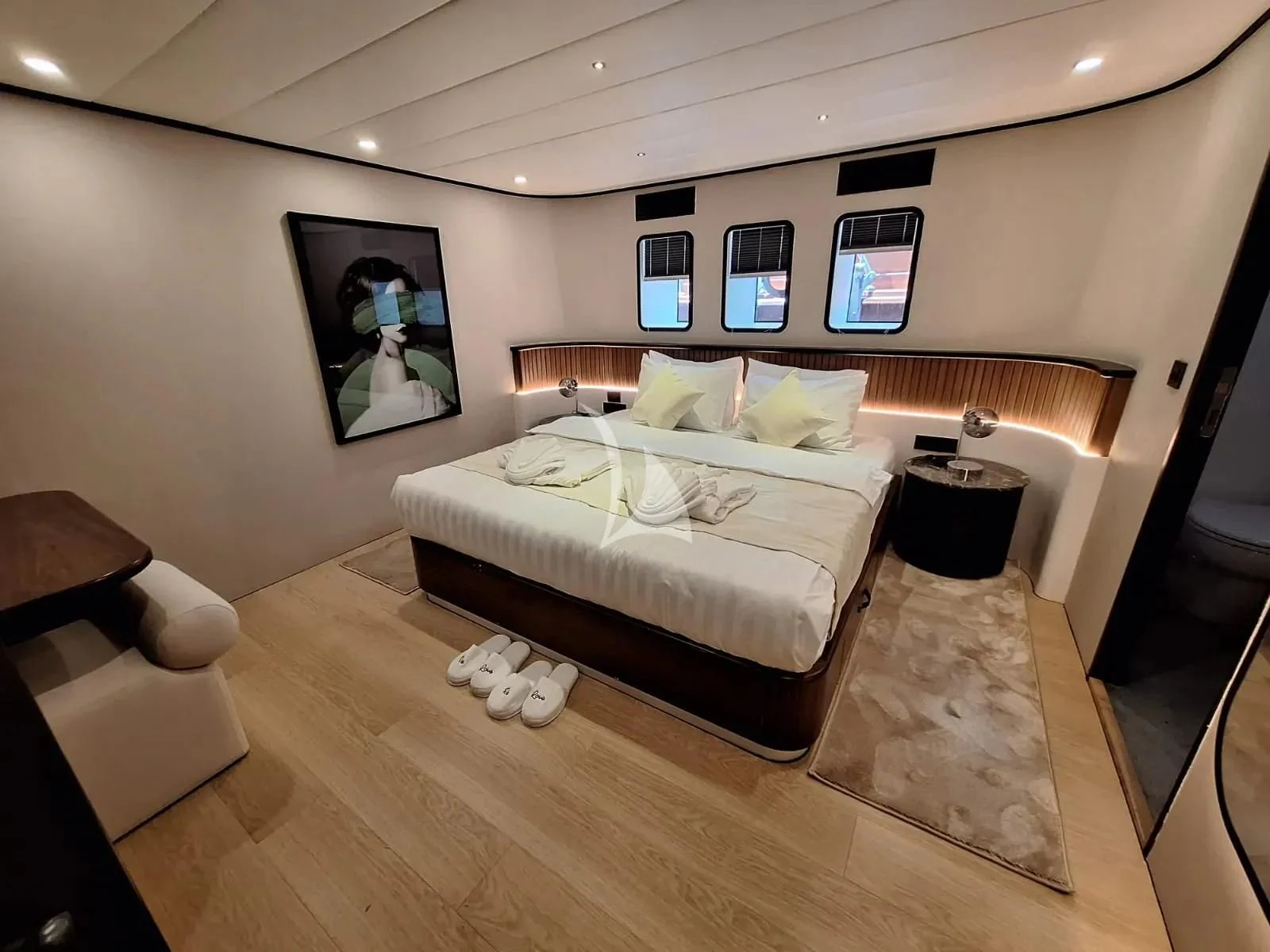 a bedroom with a bed and a chair aboard DE LOVE Yacht for Charter