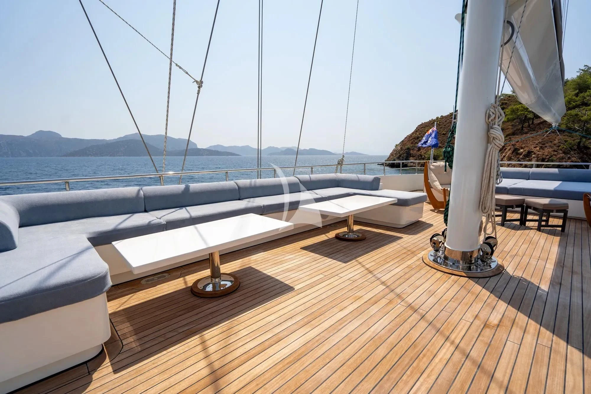 a deck with a view of the ocean and mountains aboard DE LOVE Yacht for Charter