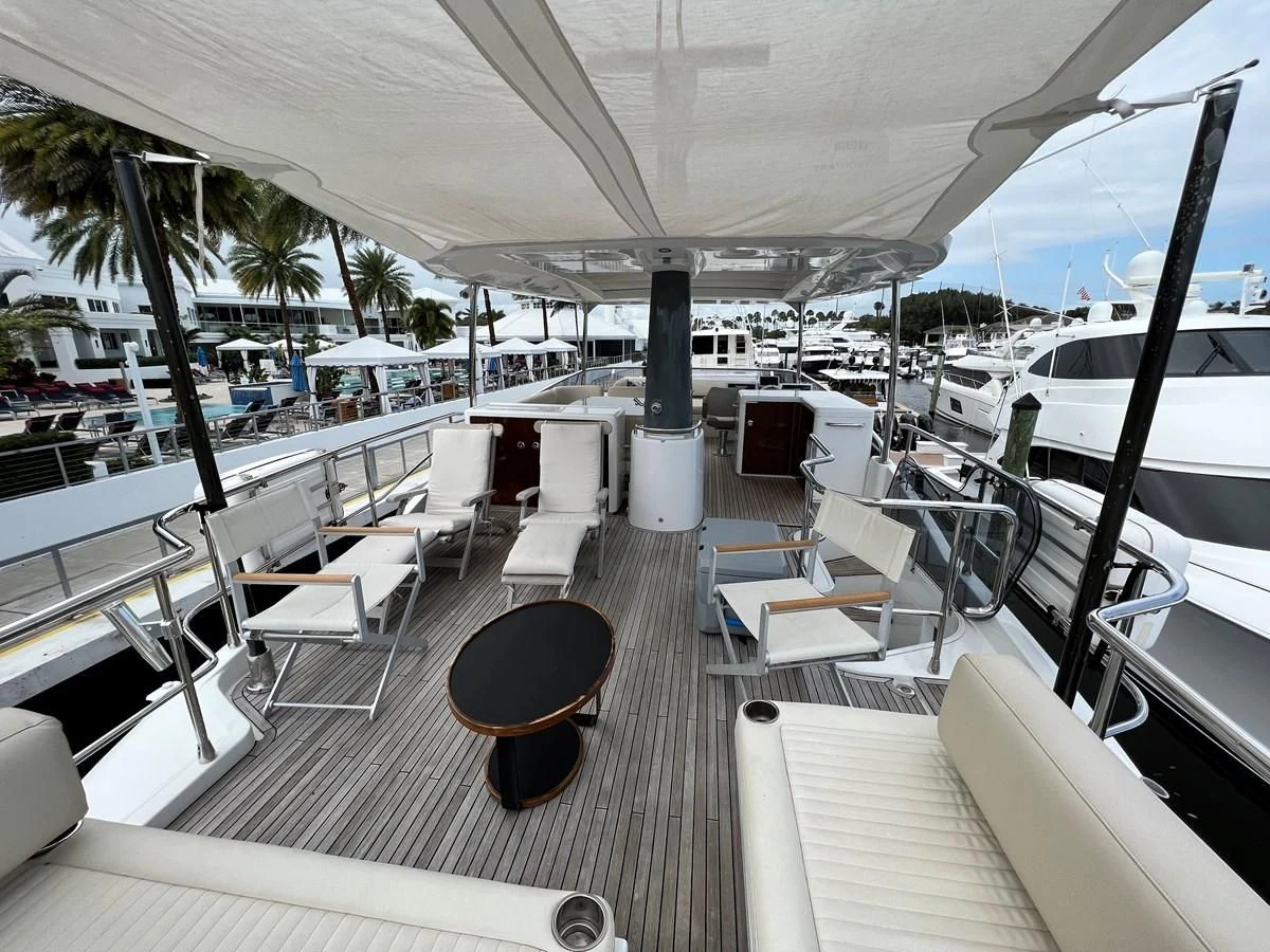 a lounge area with lounge chairs and a bar on the deck aboard PURA VIDA Yacht for Sale