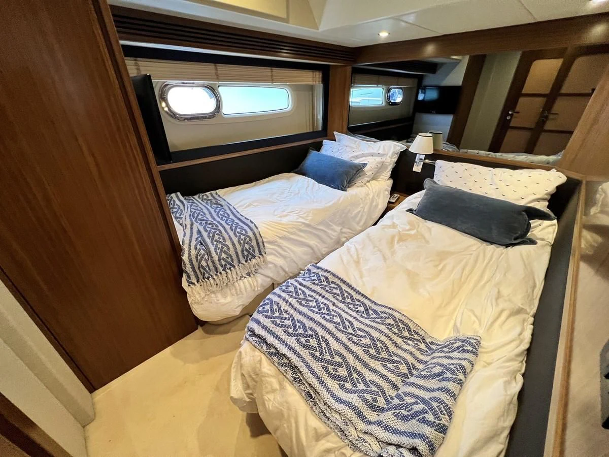 a bed with a couple of pillows aboard PURA VIDA Yacht for Sale