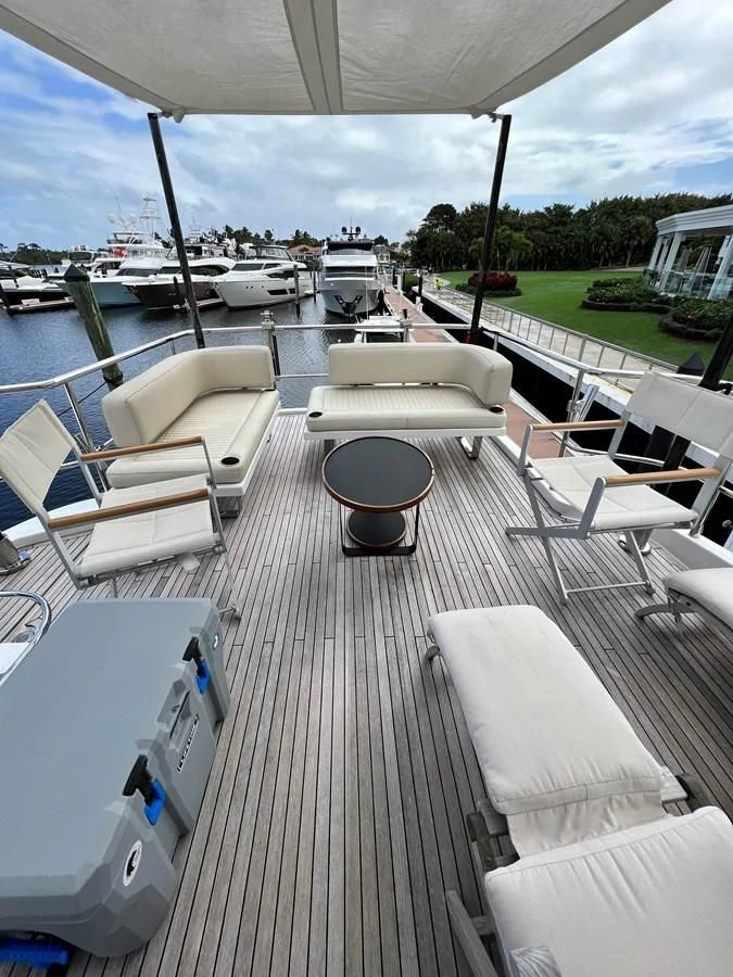 a deck with a boat and chairs aboard PURA VIDA Yacht for Sale