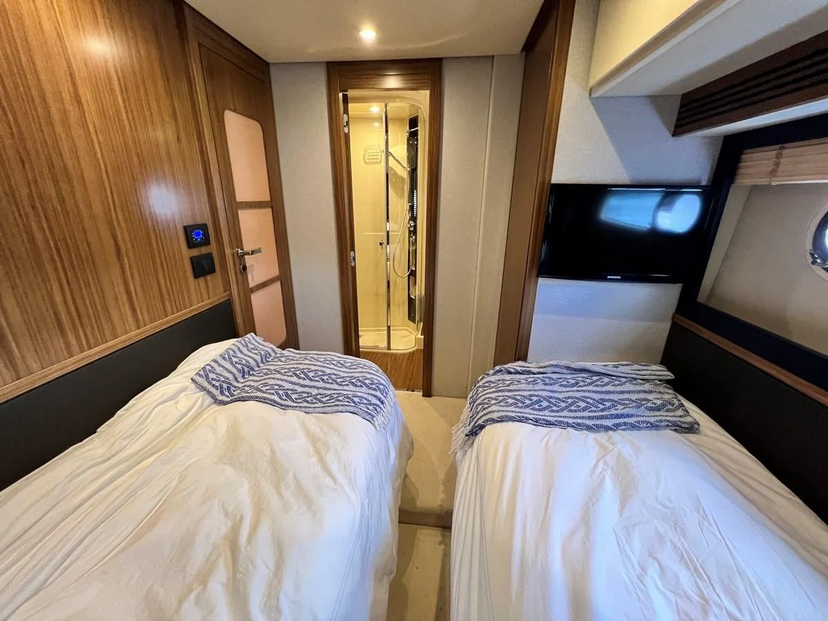 a room with a bed and a television aboard PURA VIDA Yacht for Sale