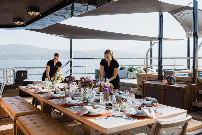 a person standing behind a table with food on it aboard PINK SHADOW Yacht for Sale