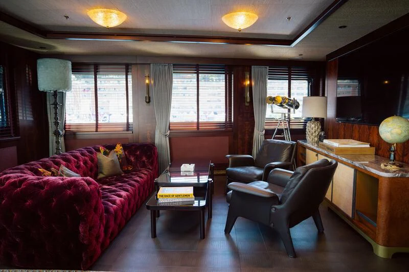 a living room with a red couch and a coffee table aboard PINK SHADOW Yacht for Sale
