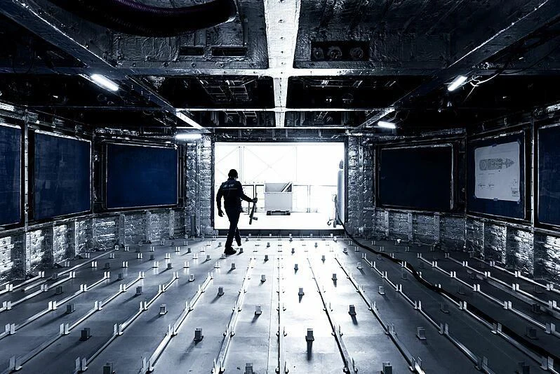 a person holding a gun in a room with many screens aboard PINK SHADOW Yacht for Sale