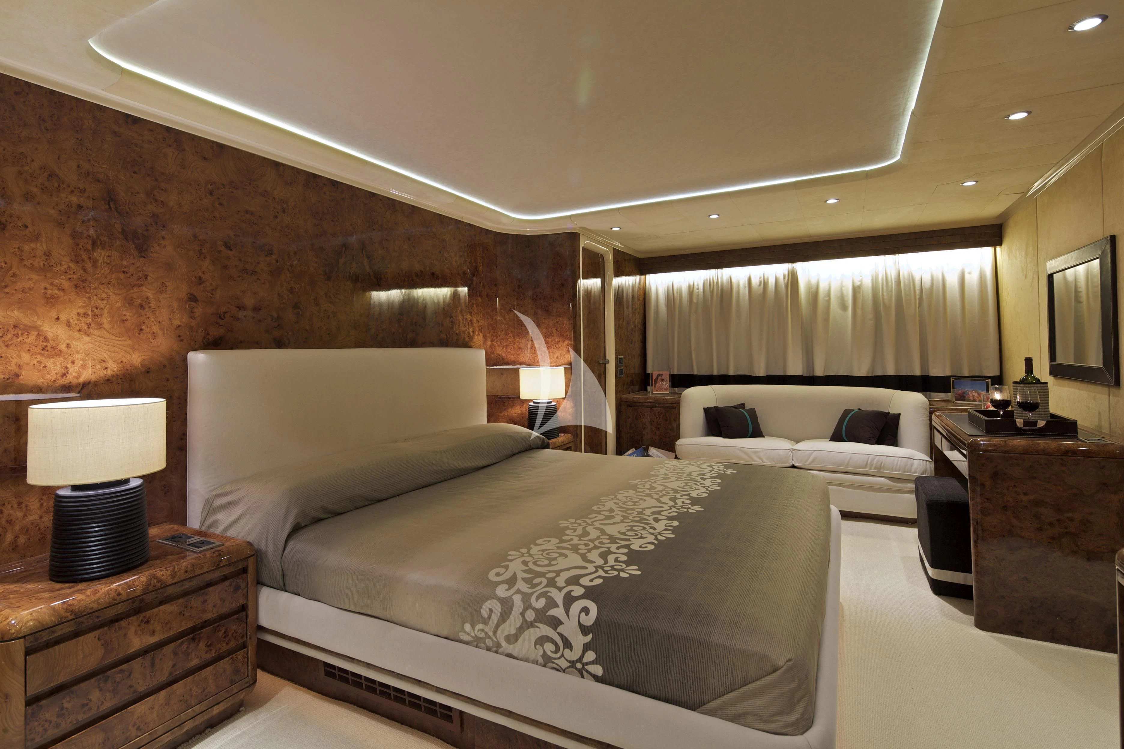 a bedroom with a bed and a couch aboard OBSESION Yacht for Sale