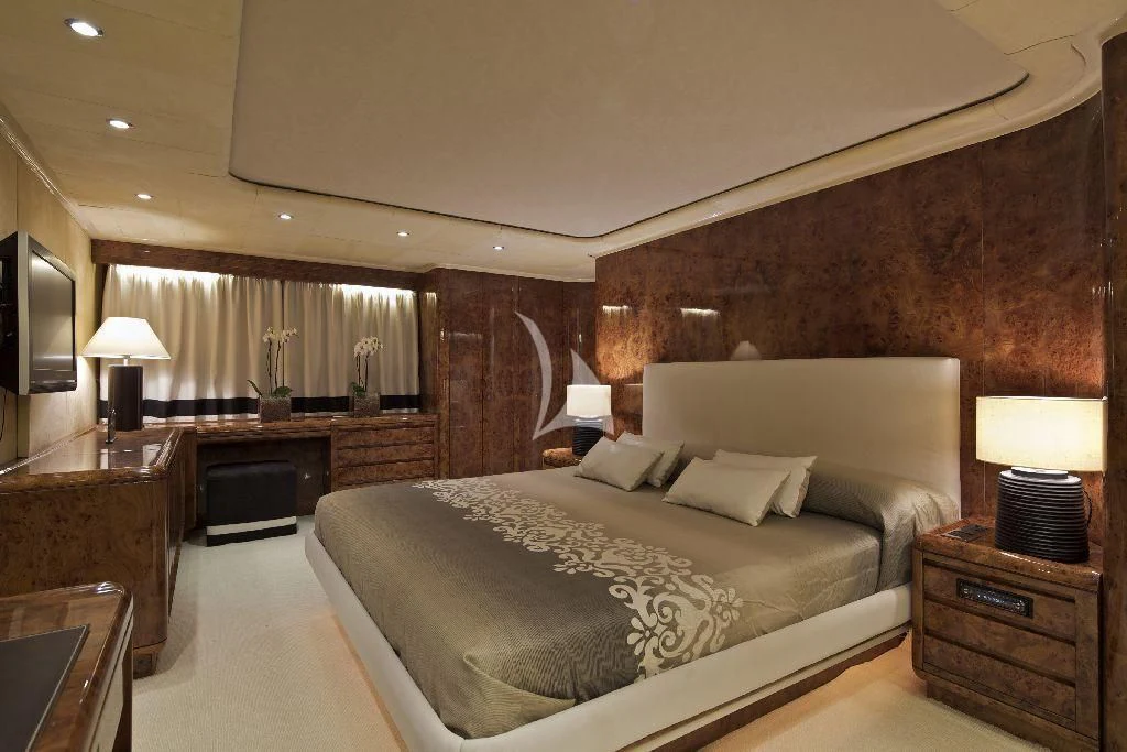a bedroom with a bed and a desk aboard OBSESION Yacht for Sale