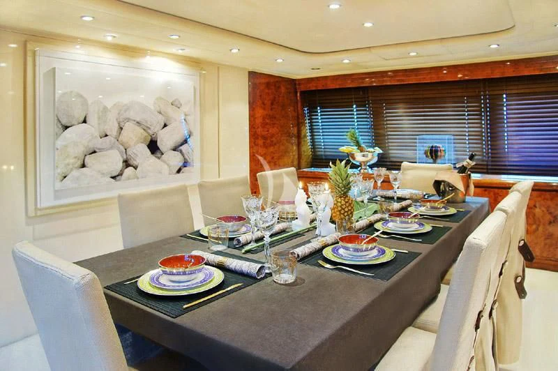 a dining table with plates and food aboard OBSESION Yacht for Sale