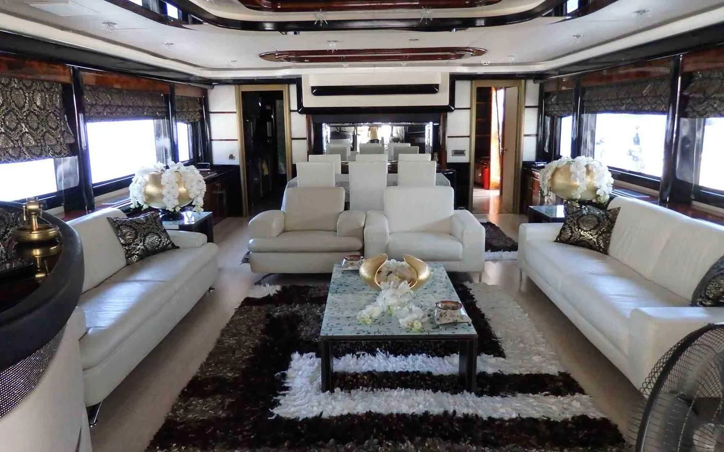 a living room with a large white couch and a table aboard ETERNITY Yacht for Sale