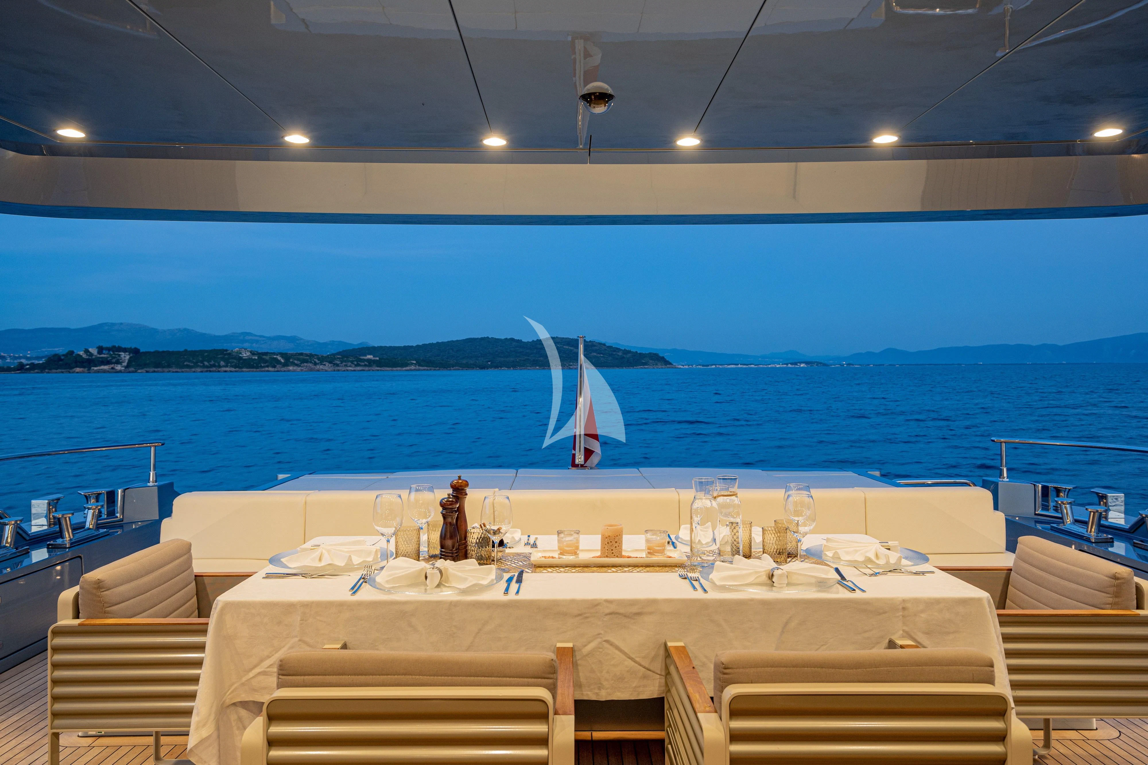 a room with a table and chairs and a sailboat in the water aboard 55 FIFTYFIVE Yacht for Charter
