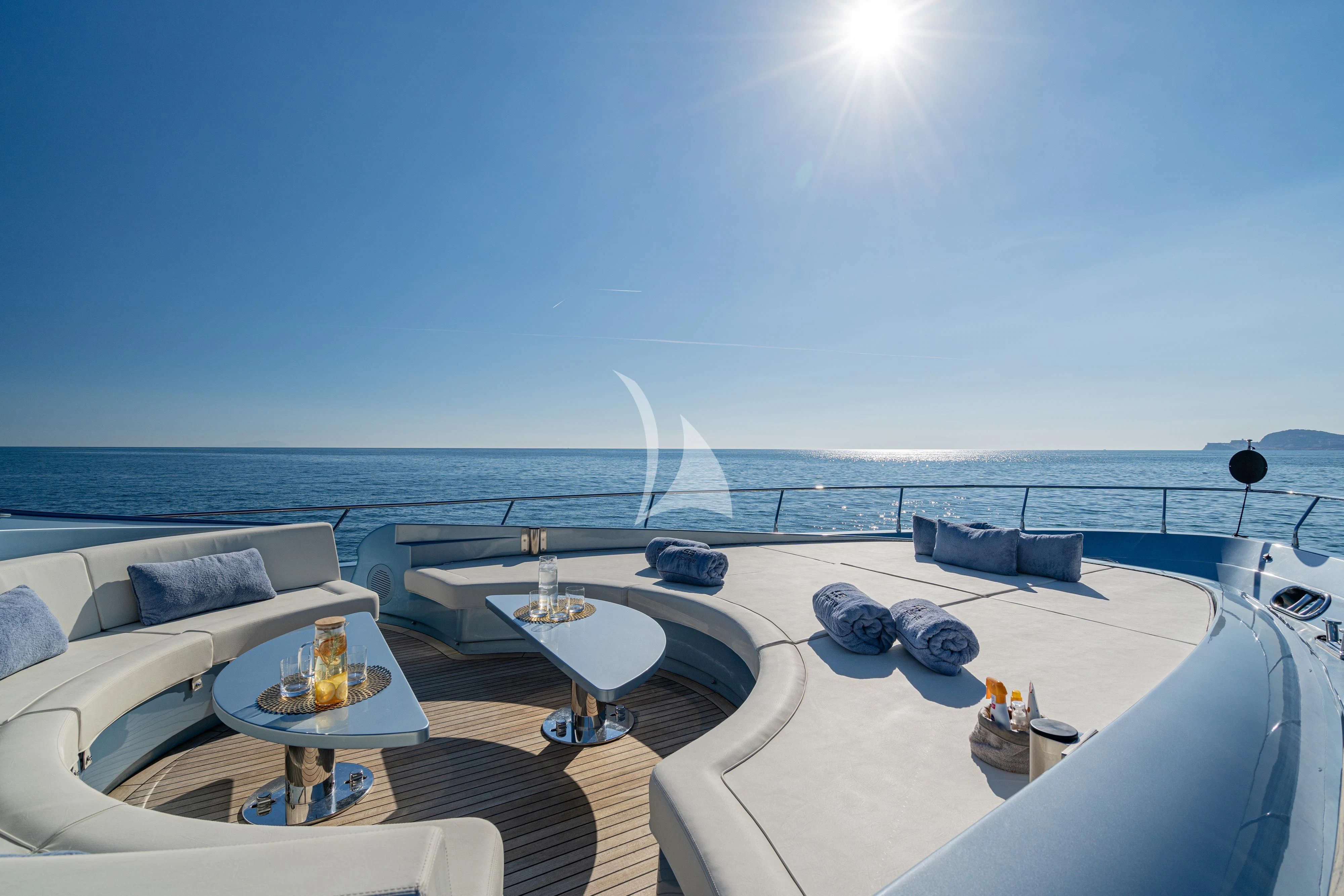 a large white lounge chair on a balcony overlooking the ocean aboard 55 FIFTYFIVE Yacht for Charter