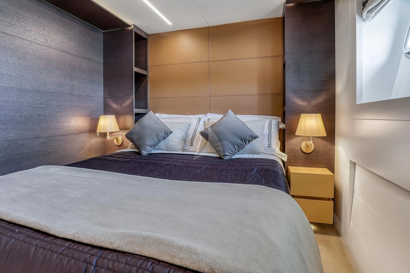 a bed with a purple comforter aboard 55 FIFTYFIVE Yacht for Charter