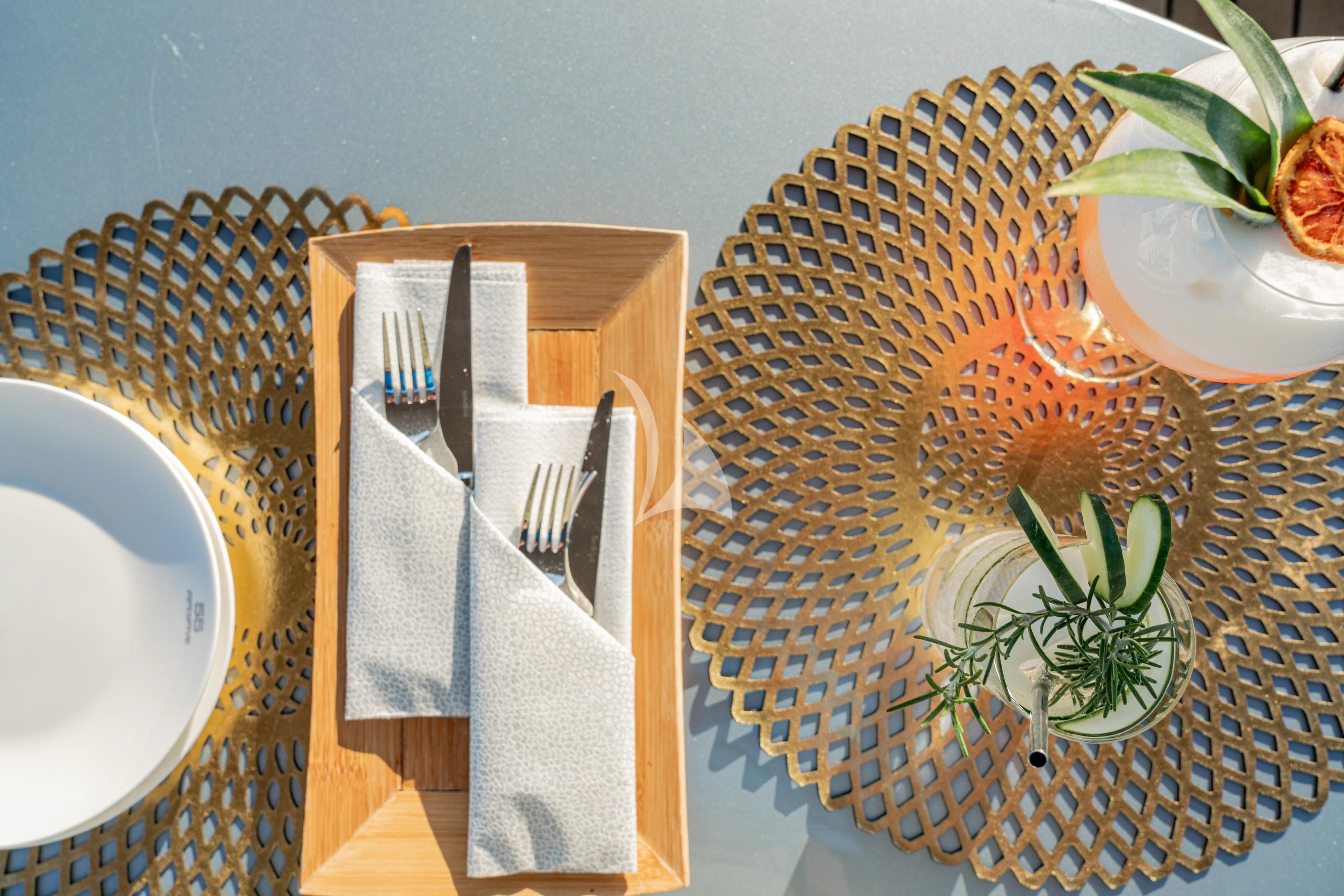 a table with plates and silverware aboard 55 FIFTYFIVE Yacht for Charter