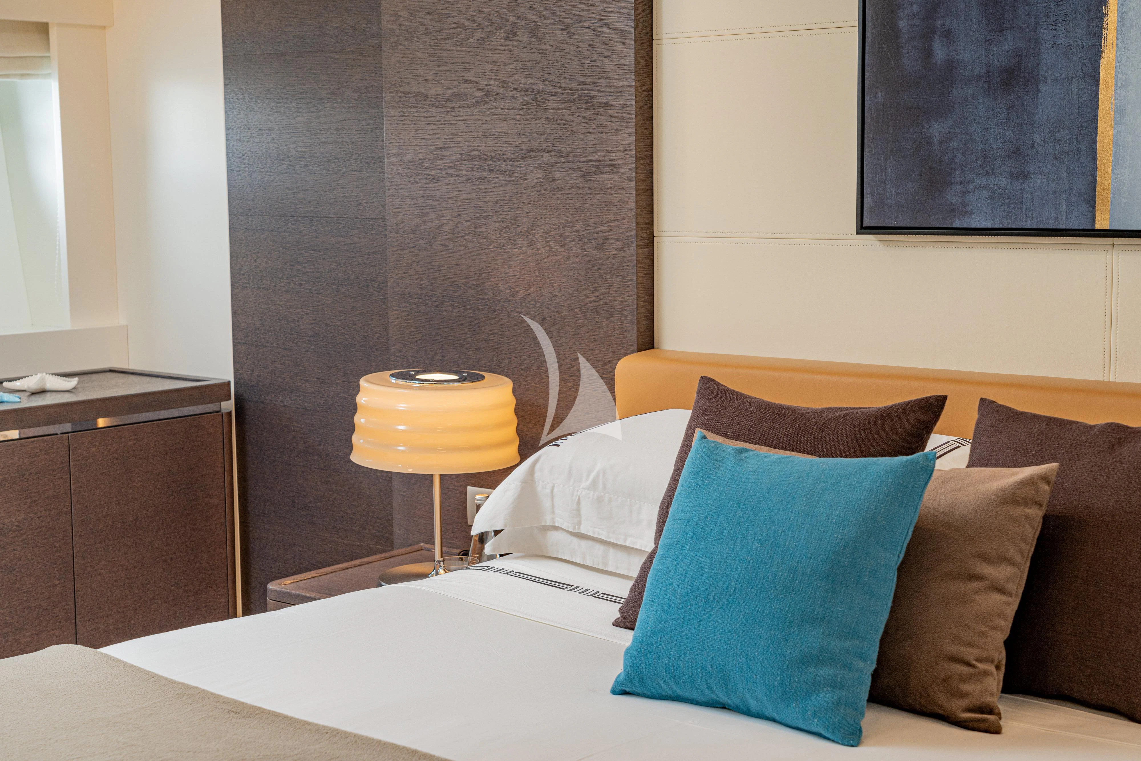 a bed with pillows and a lamp aboard 55 FIFTYFIVE Yacht for Charter