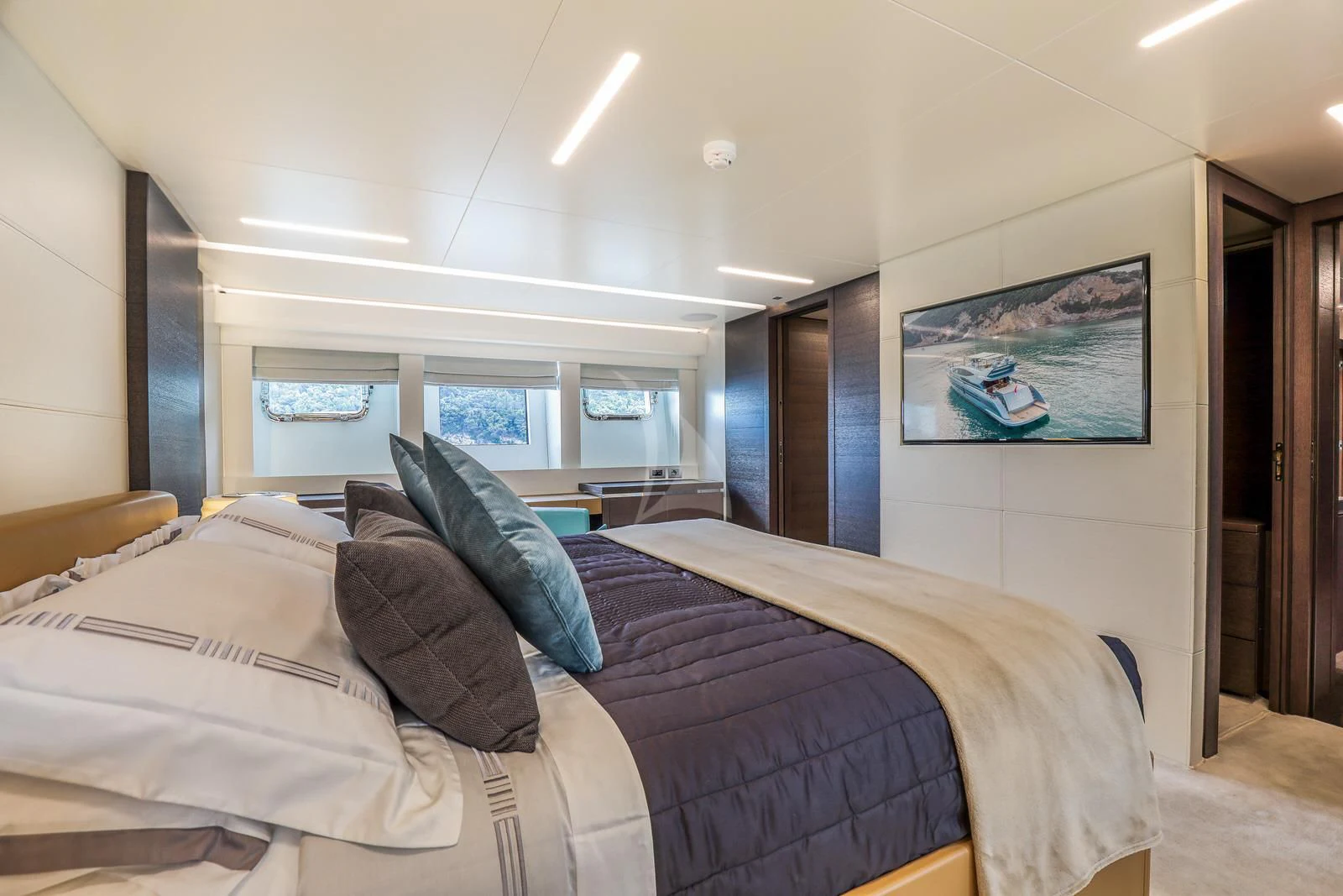 a bed with a blue pillow aboard 55 FIFTYFIVE Yacht for Charter
