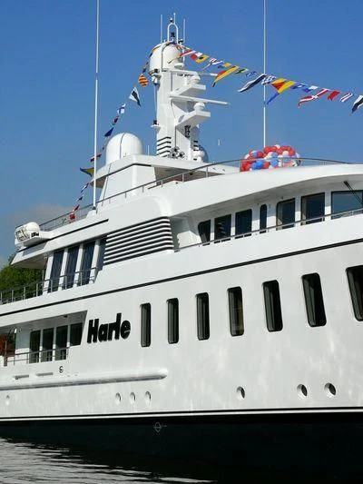 a large white boat with flags aboard HARLE Yacht for Sale